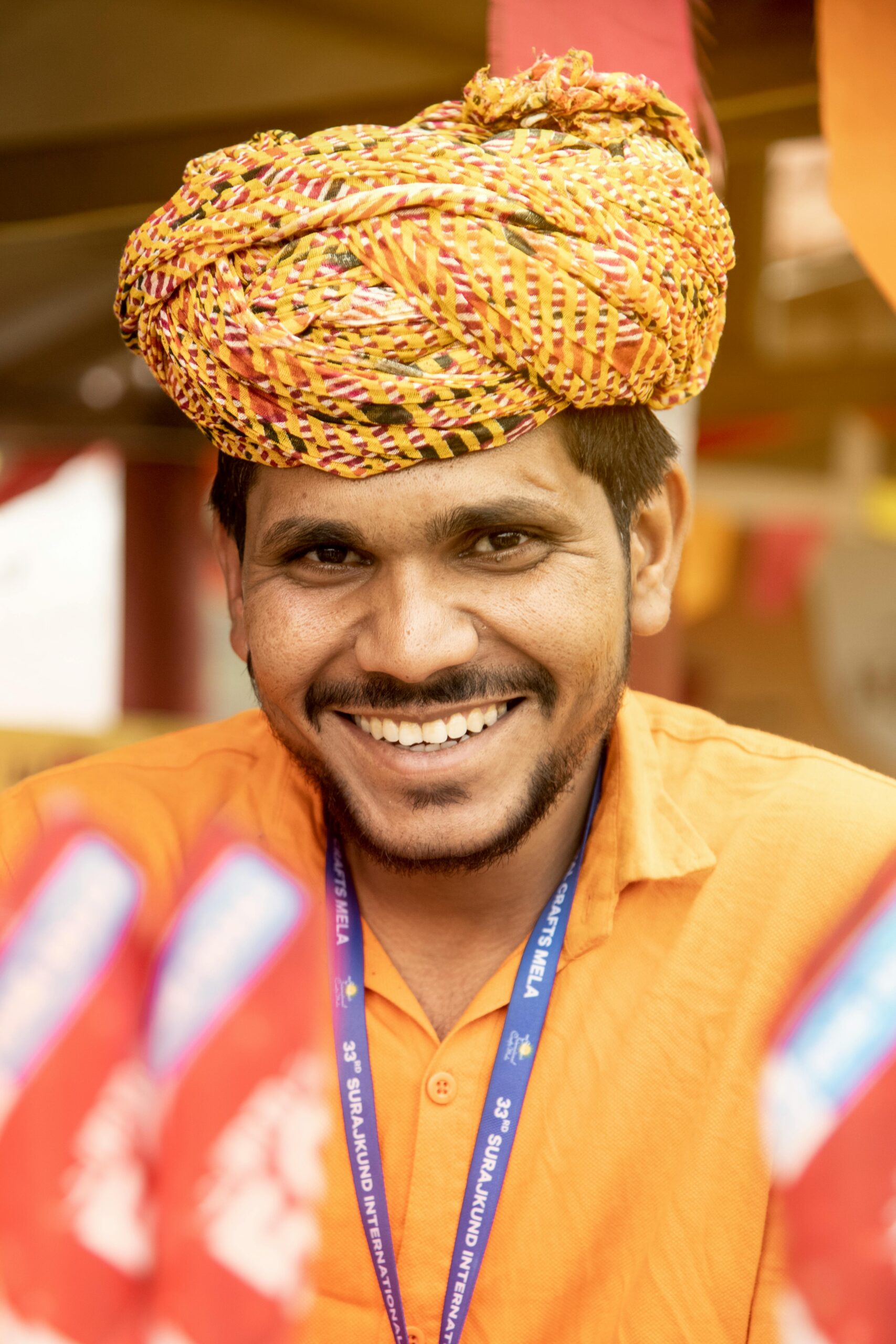 A cheerful man wearing a vibrant traditional Indian turban, showcasing cultural attire.